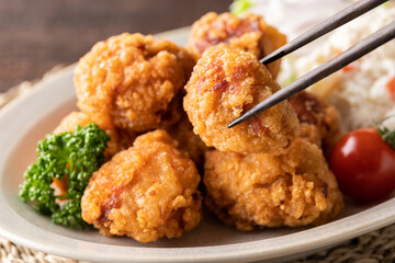 箸で挟んだ、若鶏の唐揚げのアップ