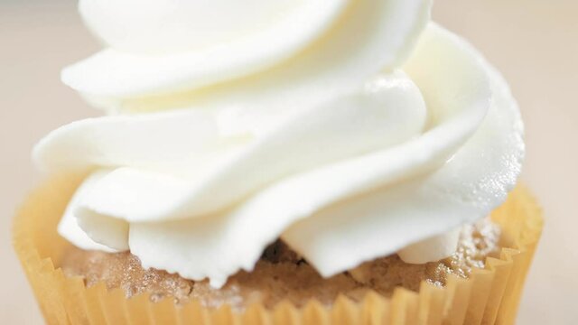 Decorating cup-cake with cream. Using cooking bag, confectioner making cupcakes for party.