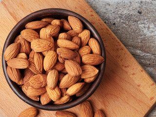 Almond in a bowl on wooden background with copy space