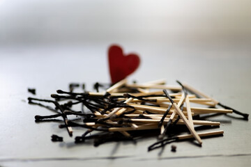 red love heart with burnt matches. end of marriage concept