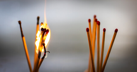 burning matches on blurred grey background. Concept of riots