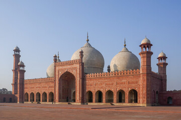 Fototapeta premium Morning view of beautiful ancient sandstone and marble landmark Badshahi mosque and courtyard built by mughal emperor Aurangzeb in Lahore, Punjab, Pakistan