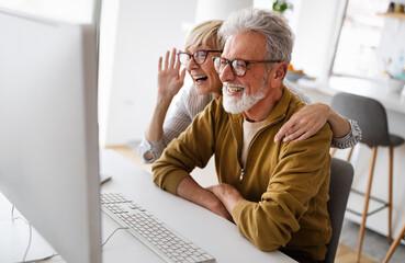 Senior retired couple learn about computer and online support.