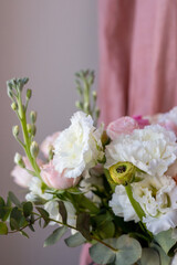 Delicate wedding bouquet in pastel shades from artificial flowers top view close-up in vase on pink fabric background