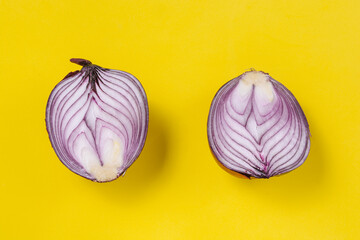 Two halves of a red onion on a yellow background