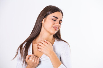 Young woman scratching her neck due to itching on a gray background. Female has an itching neck. The concept of allergy symptoms and healthcare