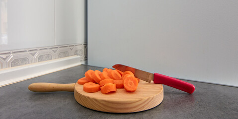 A wide-angle shot of a wooden cutting board with sliced carin the kitchen