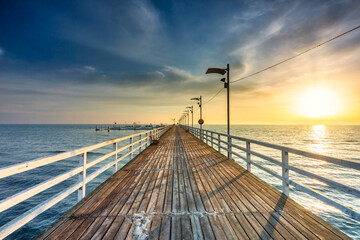 Fototapeta premium Wooden pier in Mechelinki by the Baltic Sea at sunrise, Poland.