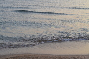 небольшие волны на песчаном пляже крупным планом вечером