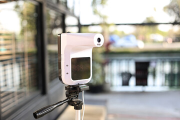 Handsfree infrared thermometer used by a restaurant for checking customer . Using this device,...