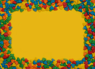  Colorful heart shape sweet candy frame on bright yellow background. Happy birthday greeting card. Holiday background. Sweet candy concept. Flat lay. Holiday Banner. Copy space for text. Love concept.