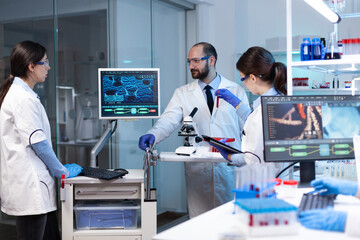 Scientists working In laboratory discovering genetic infection because of rare disease. Chemists in...
