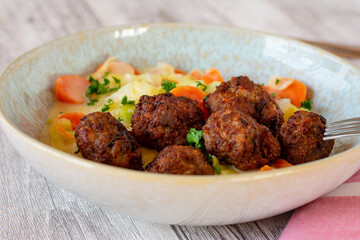 swedish meatballs with creamy vegetables on a plate