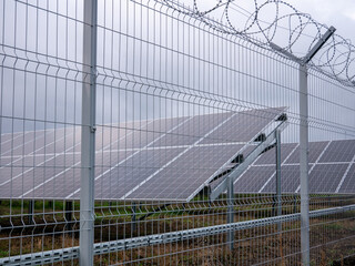 The solar station is fenced with a lattice and barbed wire