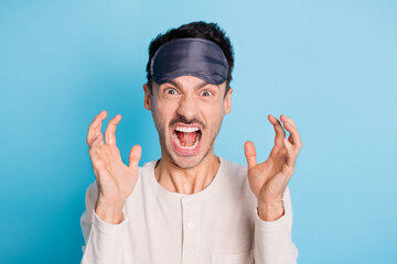 Portrait of crazy aggressive brunet guy wearing eye mask shouting bad mood isolated over bright...