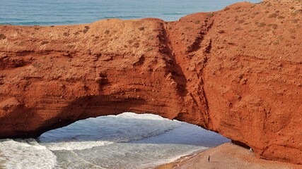 Close-up of natural giant arch and a small man