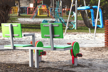 Autumn landscape playground with swings and exercise equipment in the yard