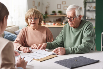 Senior couple consulting about financial documents with consultant they have a meeting at home