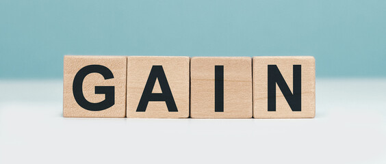 gain - word concept from wooden blocks on blue background