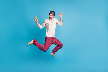 Full length photo portrait of cheerful man showing palms jumping up isolated on vivid blue colored background