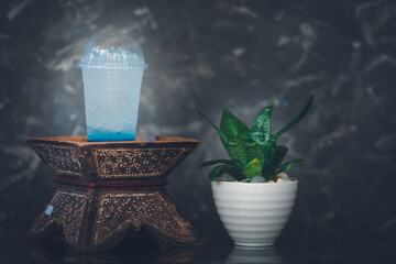 A bright colored cold drink in a glass cup on a dark background