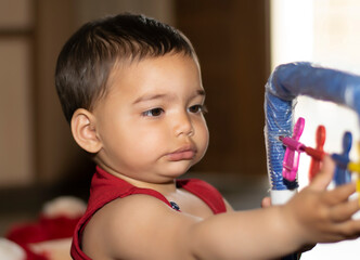 A cute baby Asian Indian baby girl  Adorable toddlers playing with toy learning numbers, mental arithmetic, abacus calculation