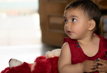 A cute baby Asian Indian baby girl  Adorable toddlers portrait closeup playing with toys. A cute baby girl .