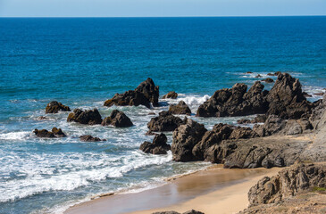 Fototapeta na wymiar ocean landscape with waves beach and rocks in daylight 