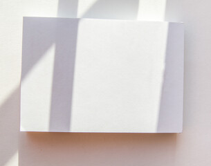 Blank notepad page layout with white sheets and geometric pattern shadow overlay effect