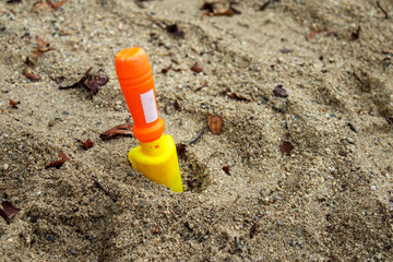 砂場に刺さったプラスチック製の子供のスコップ