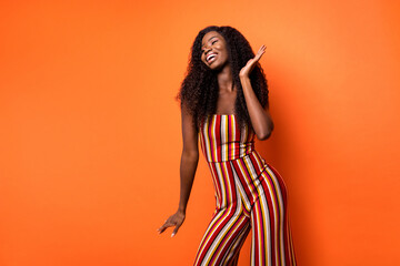 Photo of joyful relaxed happy dark skin woman dancer weekend enjoy isolated on orange color background