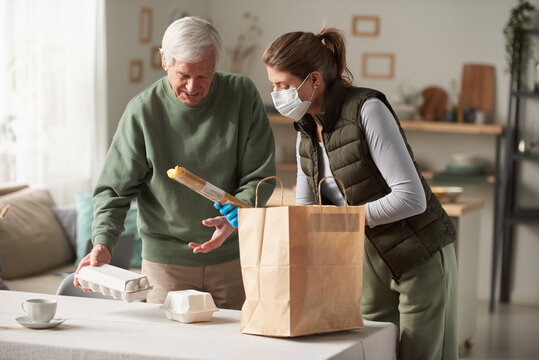 Young Volunteer In Mask Helping To Elderly Man She Bringing Food To Home For Him