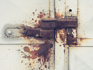 Rusty latch and lock housing, rusty metal door frame. Advanced corrosion