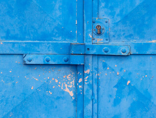 Armored metal double door with massive lock on blue garage gate - 416480393