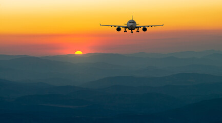 Fototapeta na wymiar Passenger airliner fly on beauty sunrise or sunset mountain landscape