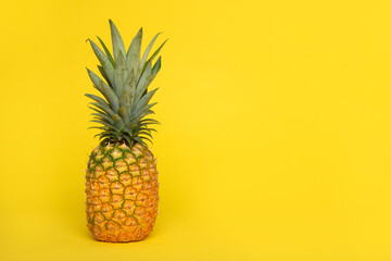 Pineapple on a yellow background with copy space