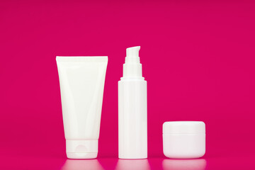 Cleansing gel, face cream and under eye cream against pink background. Concept of set for daily skin care or anti aging beauty routine