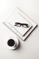 Office desk table with supplies, coffee cup and flower. Top view