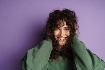 Happy beautiful curly girl smiling holding her head