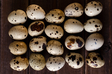 Top view of row of quail eggs on the brown wooden table.Quail eggs as a background