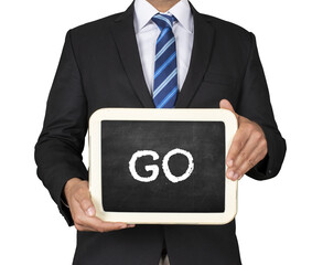 A Businessman holding slate mini blackboard with message Go