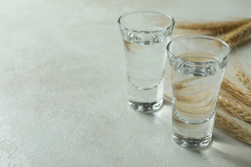 Shots of vodka and spikelets on white textured table