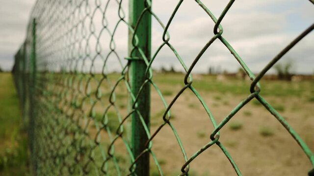 Border fence. Private territory. Closed area. Metal mesh. Protection from refugees. Prison net.  Life in captivity. The escape.