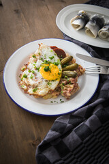 Norddeutscher Hamburger Labskaus mit Rindfleisch Corned Beef, Rote Beete, Kartoffeln, Saure Gurken, Spiegelei und Rollmops auf Emaille Teller