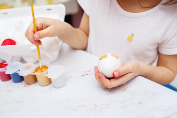 children's hands draw an easter egg paint brush in red. paint stains on the background. Daily life dirty stain for wash and clean concept. High quality photo
