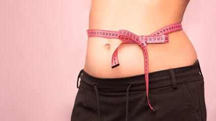 bow of centimeter ribbon on the waist of a woman, the concept of weight loss, healthy lifestyle.