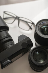 Workplace with a modern equipment for photography. Mirrorles camera and prime lenses.