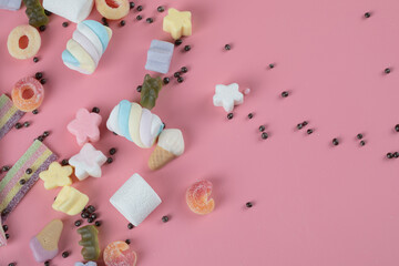 Marshmallow and jelly beans mix on the pink background