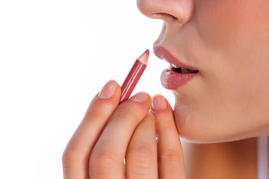 woman applies lip pencil