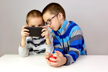 Two little boys playing a game on the smartphone